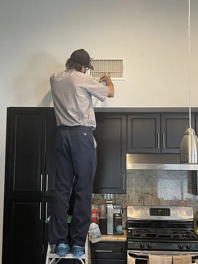 Technician inspecting an air vent during HVAC service in Millbury